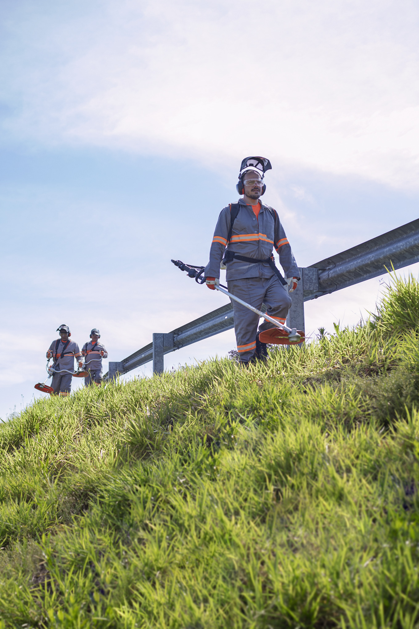 Homens com a FR 410 cortando um canteiro de rodovia