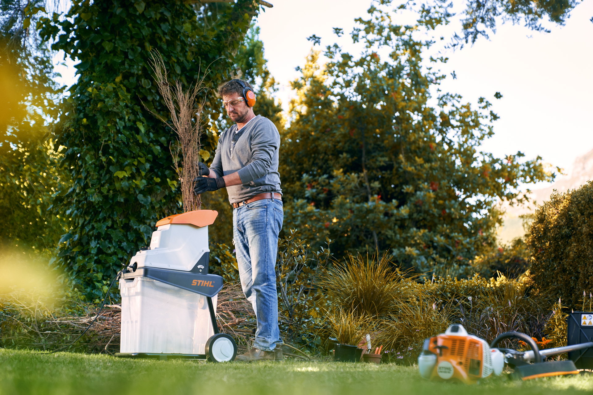 Um homem a usar um biotriturador elétrico STIHL GHE 140 para posteriormente mostrar como fazer compostagem