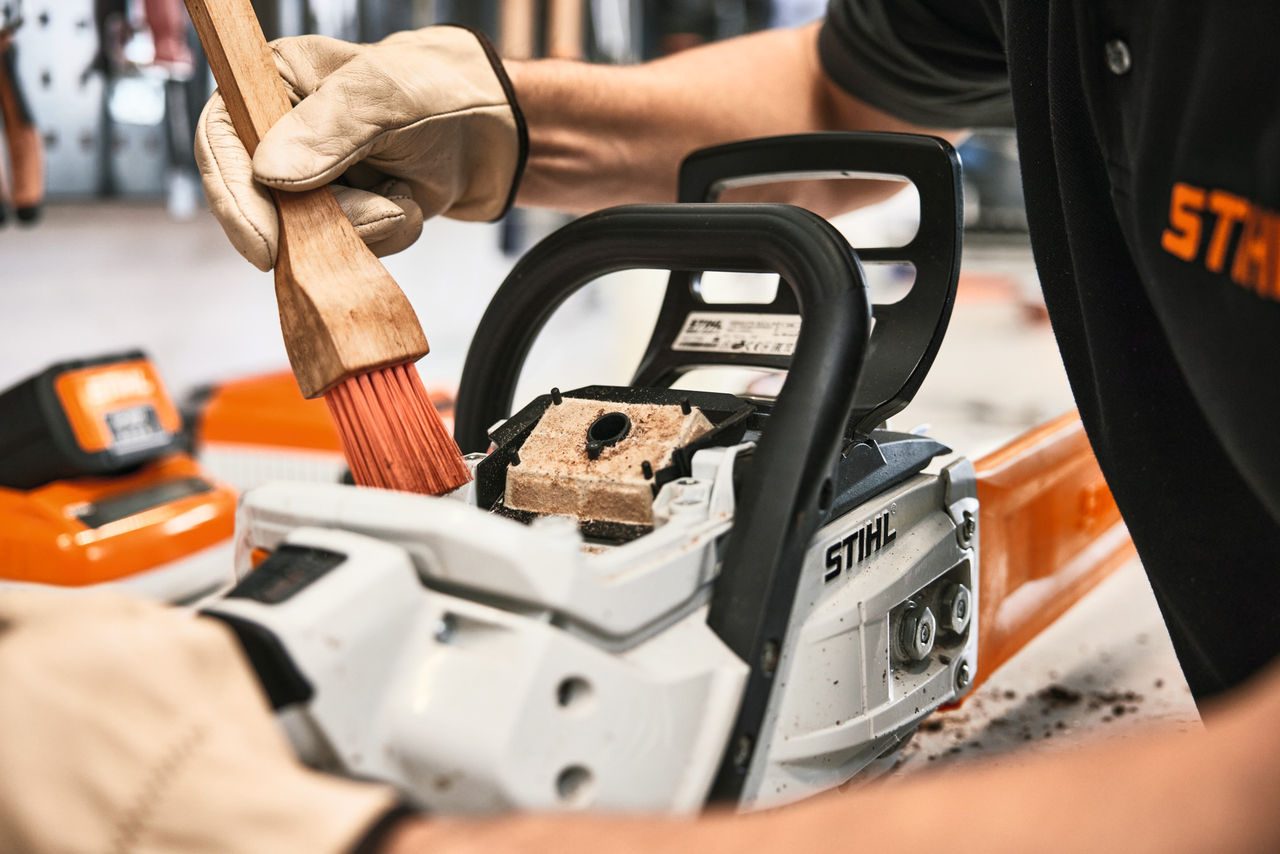 Manutenção da motosserras sendo realizada por funcionário da loja STIHL